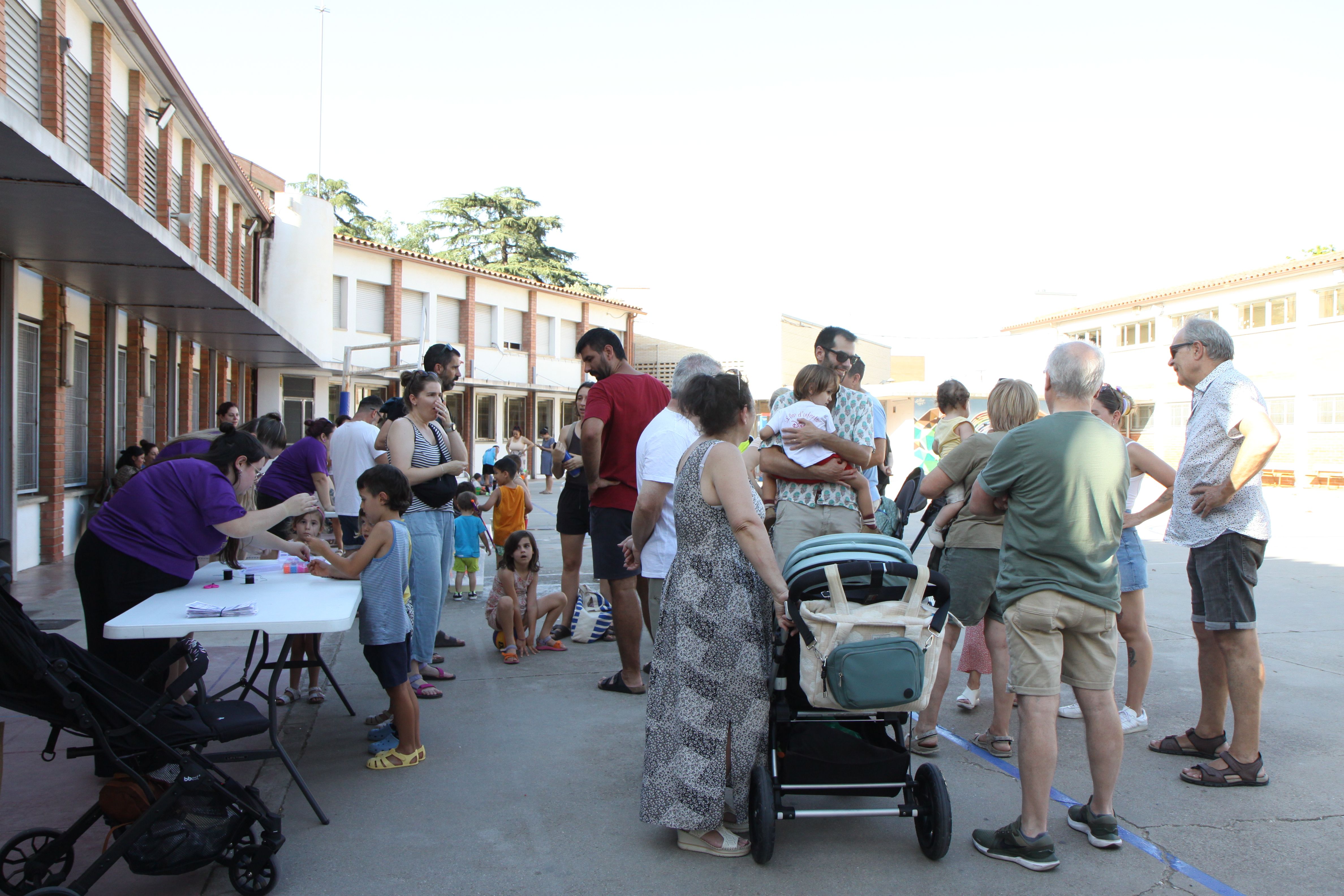 L'espai d'ombra ple de famílies durant la inauguració dels patis oberts. Foto: Laia Jubany