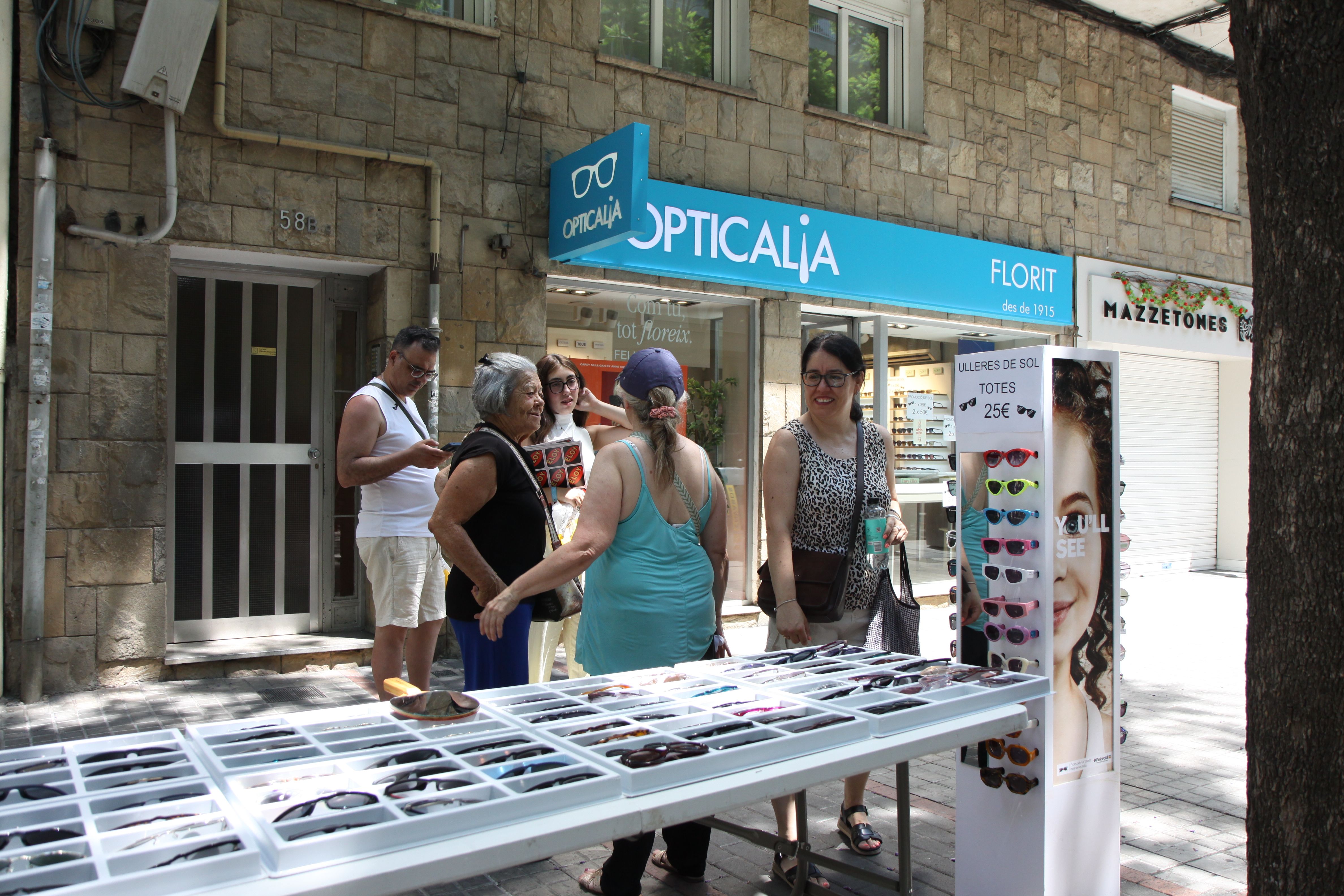Un grup de veïns xerrant davant la paradeta d'Opticalia. Foto: Laia Jubany