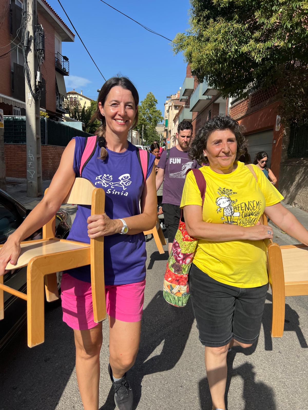 Membres de la comunitat educativa de La Sínia porten les cadires durant la manifestació per reclamar el segon grup d’I3. FOTO: Judit Josa