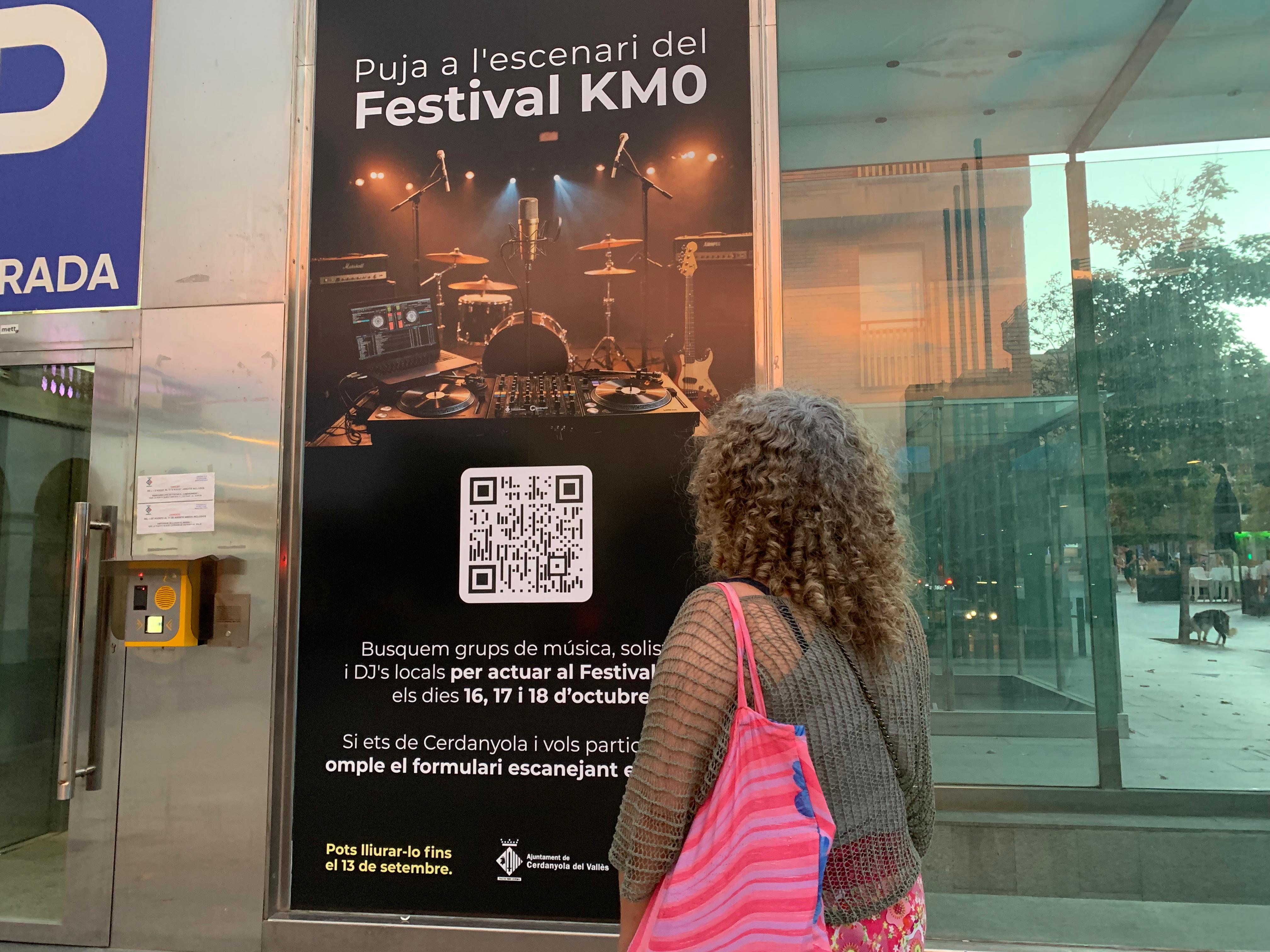 Una dona es mira el cartell sobre el Festival Km0. Foto: Judit Josa