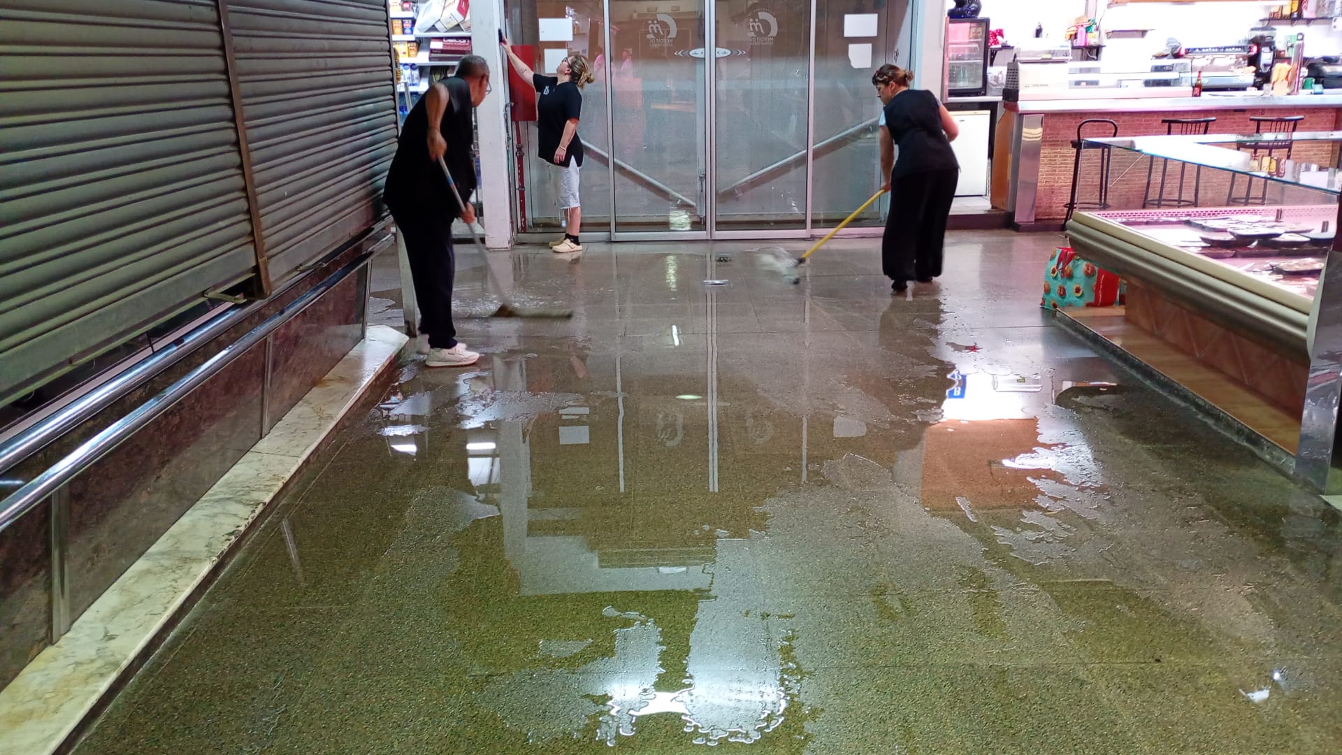 Paradistes retiren dijous  l’aigua que va entrar al Mercat de Serraparera  durant la nit i matinada de dimecres a dijous. FOTO: Cedida.