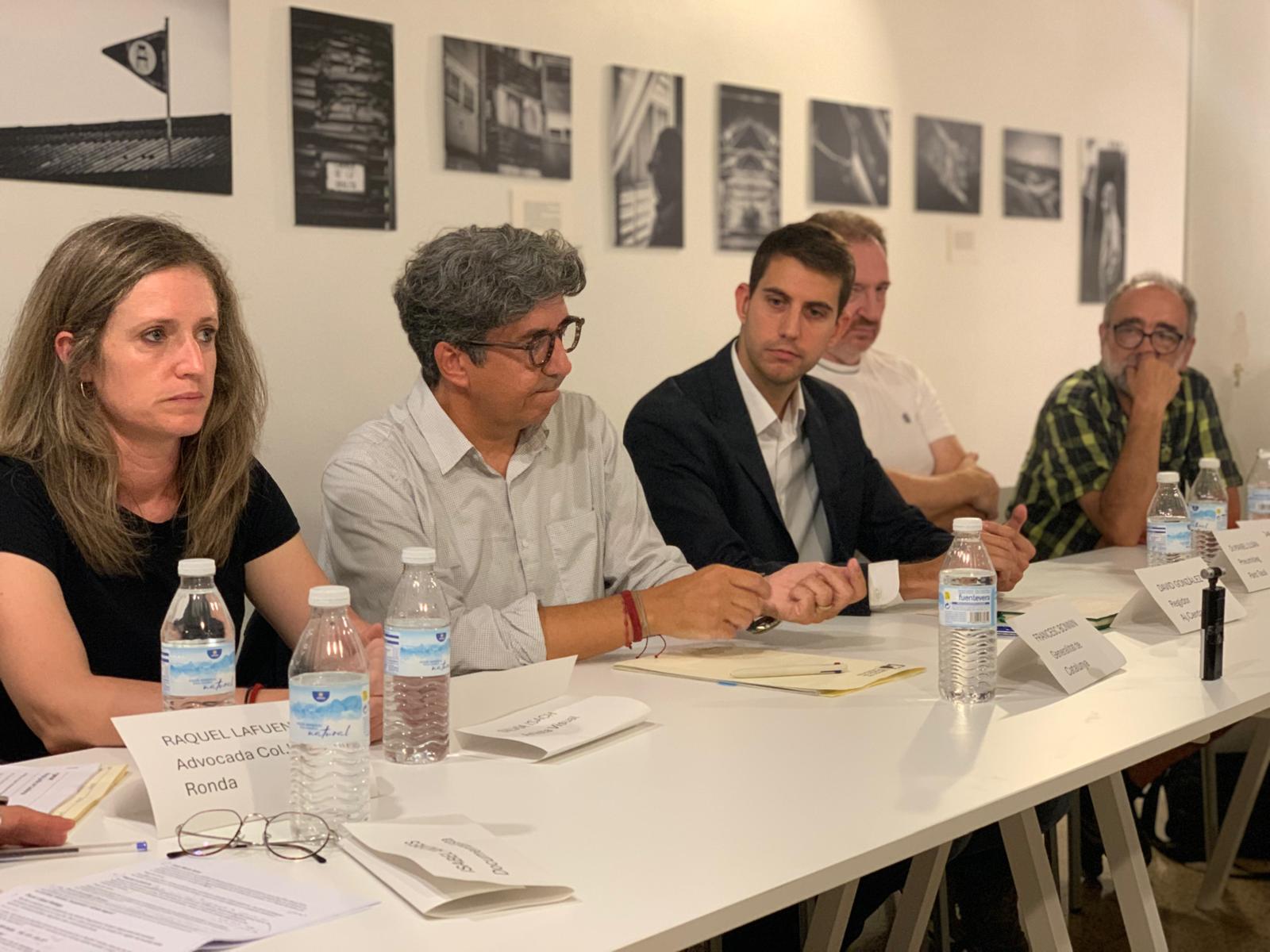 D’esquerra a dreta, Sílvia Isach, Francesc Bonnin, David González, Manel Luján i Joan Maria Soler, durant la taula rodona ‘Vida sense amiant’, amb les fotografies de ‘L’herència latent’ al fons. FOTO: Judit Josa