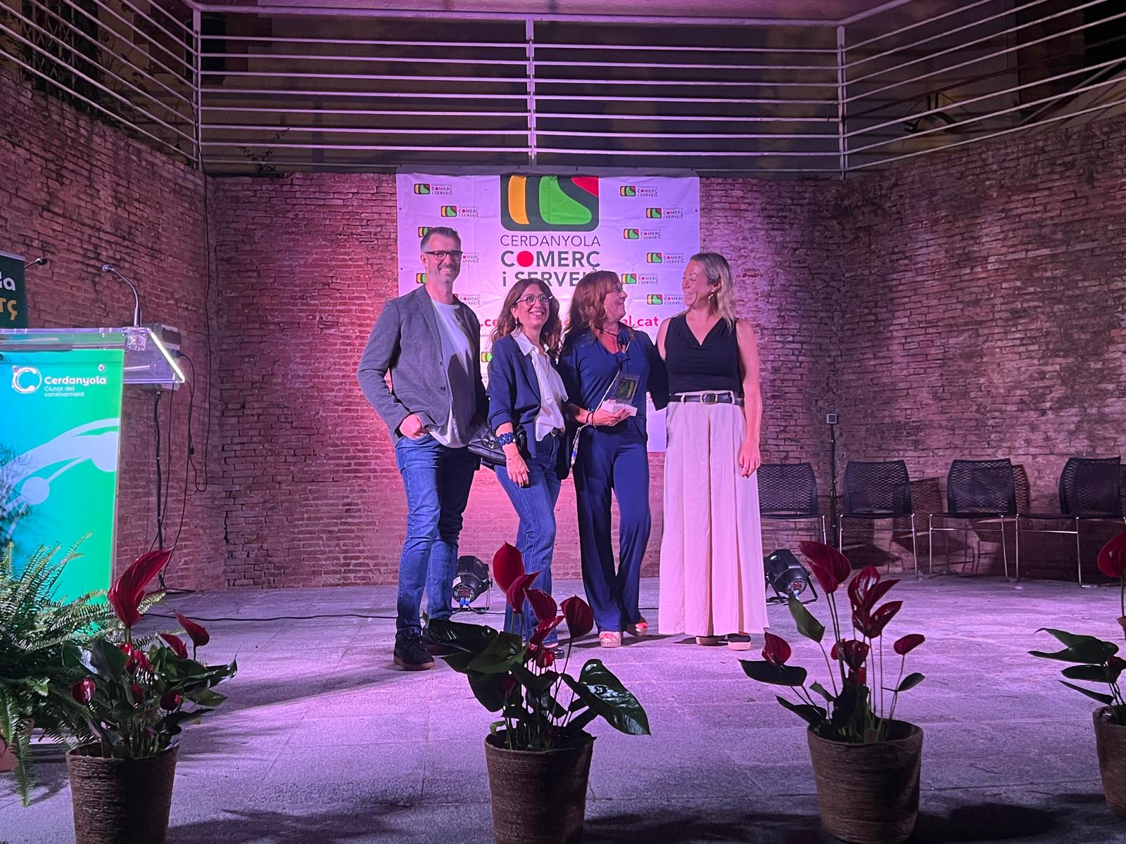 Maricruz, de Discobolo, comparteix una mirada amb la regidora de Promoció Econòmica, Comerç i Mercats, Cristina Padilla, després de rebre el reconeixement de Comerciant de l’Any. A la imatge, també Xavi Olivé, president de CCS. FOTO: Judit Josa