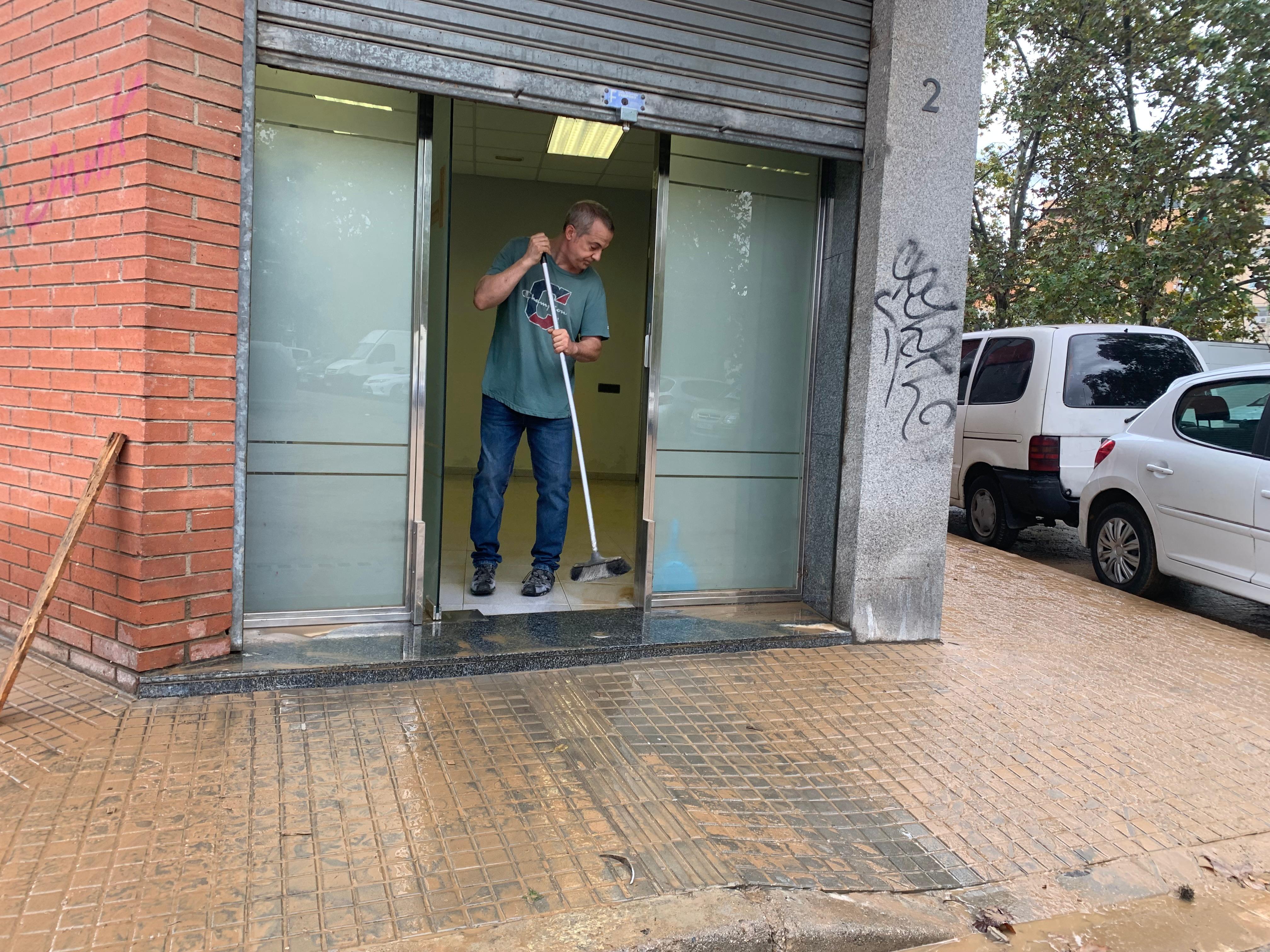 Un veí de Can Xarau retira l’aigua d’un dels locals afectats. FOTO: Judit Josa