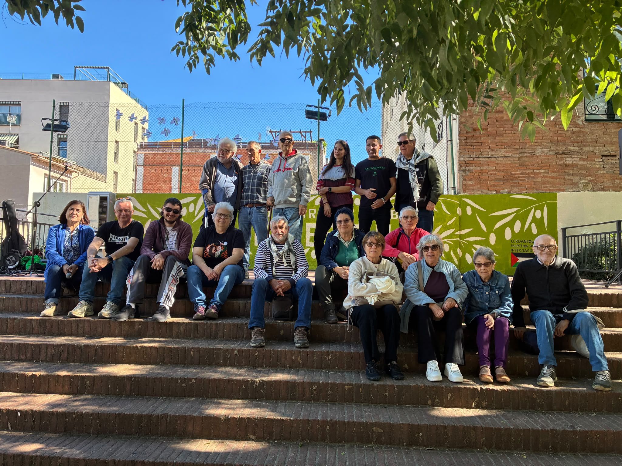 Foto de família dels participants en la pintada del mural i els representants de la Comunitat Palestina a Catalunya. Foto: Laia Jubany