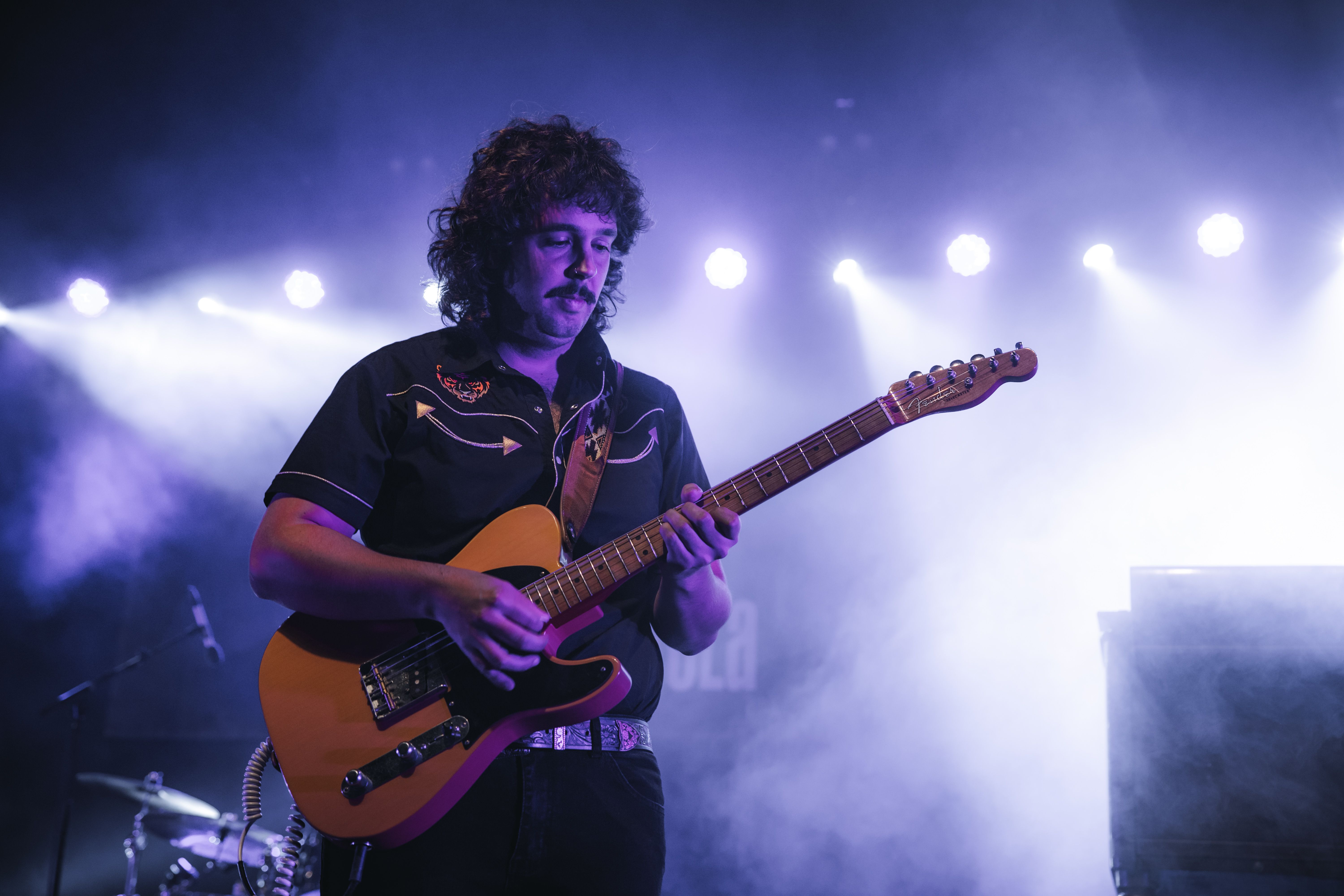 Un dels guitarristes de Ster Wax, sota els focus de la Carpa Xarau. FOTOS: Arnau Padilla