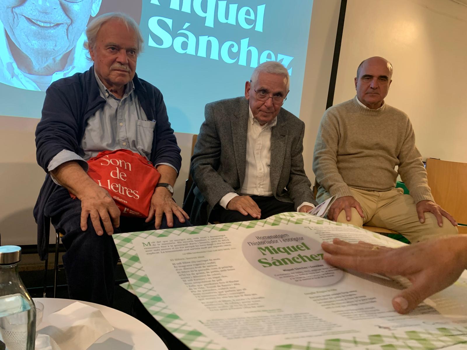 Miquel Sánchez, al centre, amb Francesc Parcerisas i Vicent Guallart, durant l'homenatge a l'Ateneu. En primer terme, les estovalles commemoratives amb fragments de la seva obra. FOTO: Judit Josa