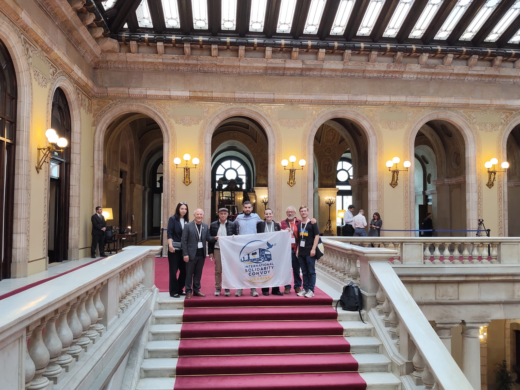 Manel Navarro, amb gorra, i altres membres del Comboi Internacional de Solidaritat amb Ucraïna, a les escales del Parlament de Catalunya. FOTO: Cedida